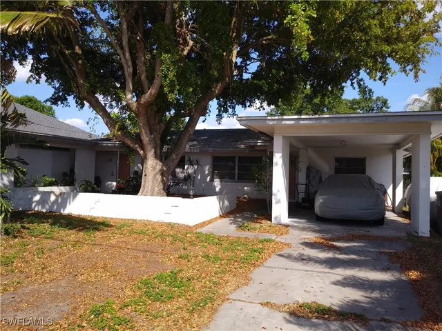 a view of a house with a patio and a yard
