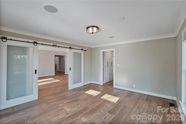a view of empty room with wooden floor