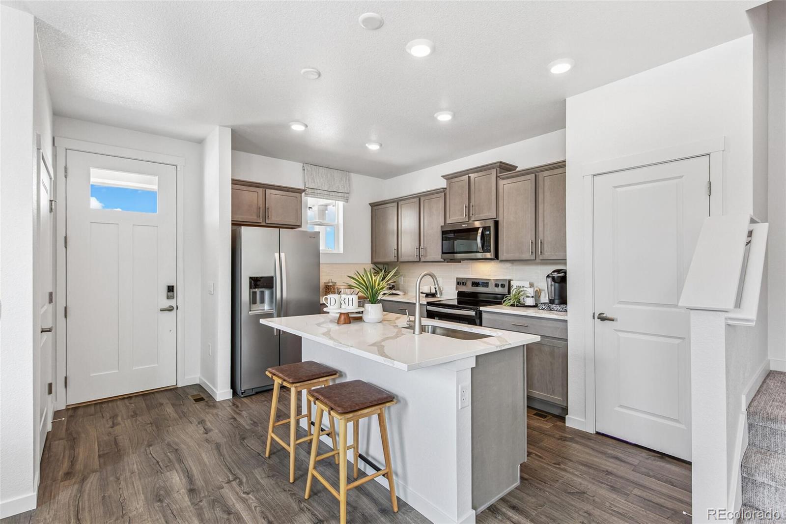 1389 South Chester Street, Unit A Denver, CO 80247 - Photo 9 of 30 a kitchen with a refrigerator a stove top oven a sink and cabinets