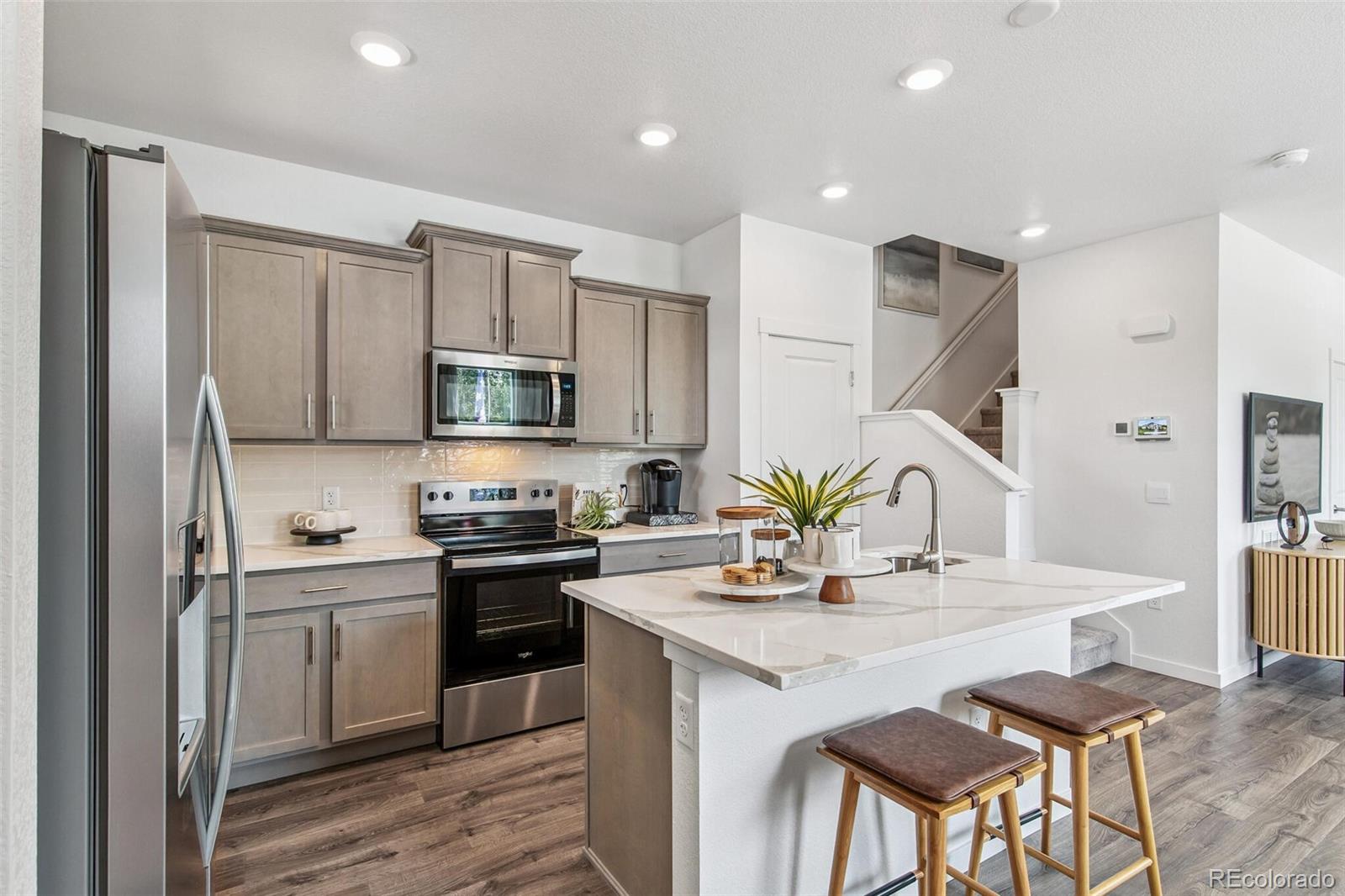 1389 South Chester Street, Unit A Denver, CO 80247 - Photo 10 of 30 a kitchen with stainless steel appliances granite countertop a sink a stove a microwave a refrigerator and cabinets
