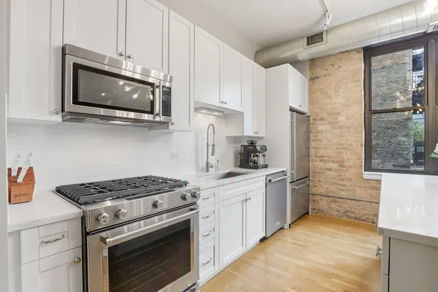 a kitchen with stainless steel appliances white cabinets and stove