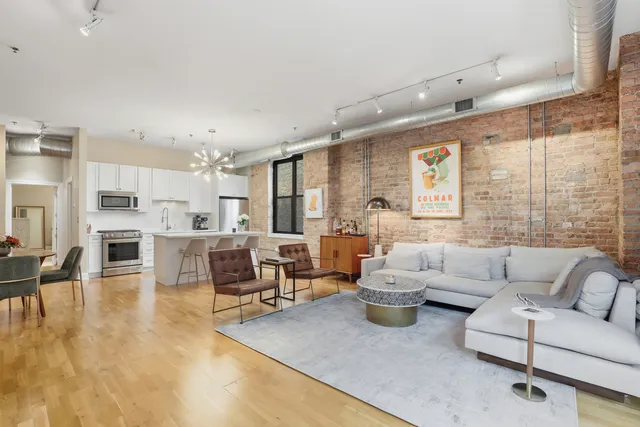 a living room with furniture white walls and kitchen view