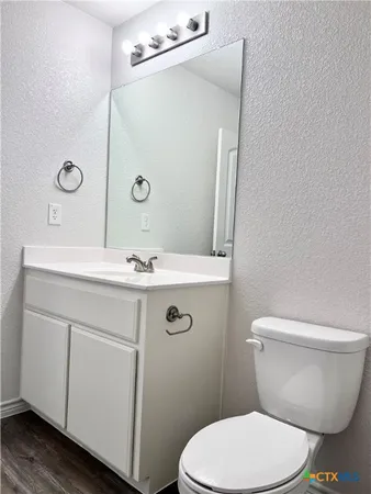 a bathroom with a sink mirror vanity and toilet