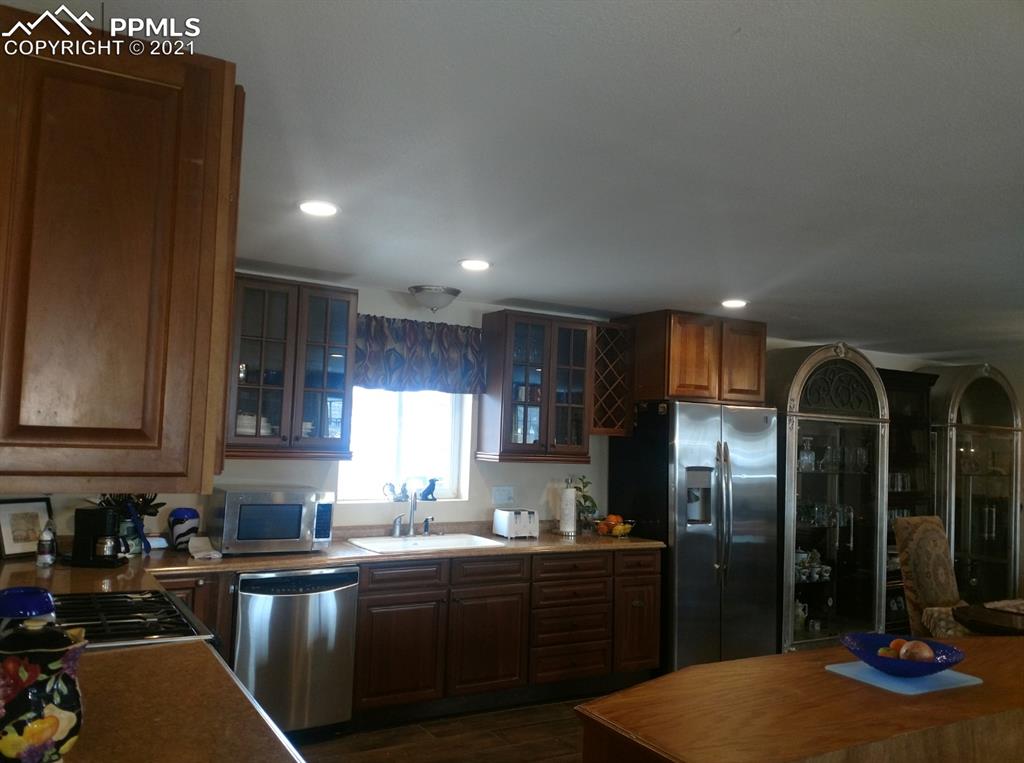 476 Elbert Street Elizabeth, CO 80107 - Photo 6 of 16 a kitchen with stainless steel appliances granite countertop a refrigerator a sink dishwasher with wooden cabinets and floor