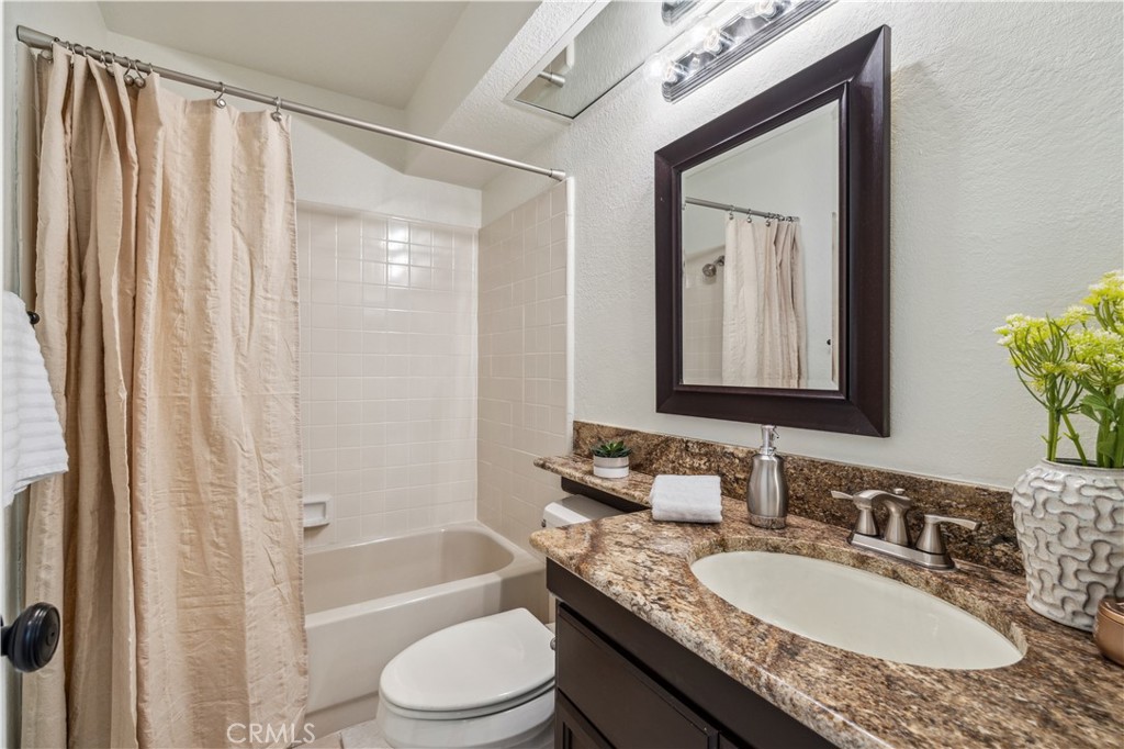 1 Suffolk Downs Laguna Niguel, CA 92677 - Photo 19 of 33 a bathroom with a granite countertop sink vanity mirror bathtub shower and a toilet