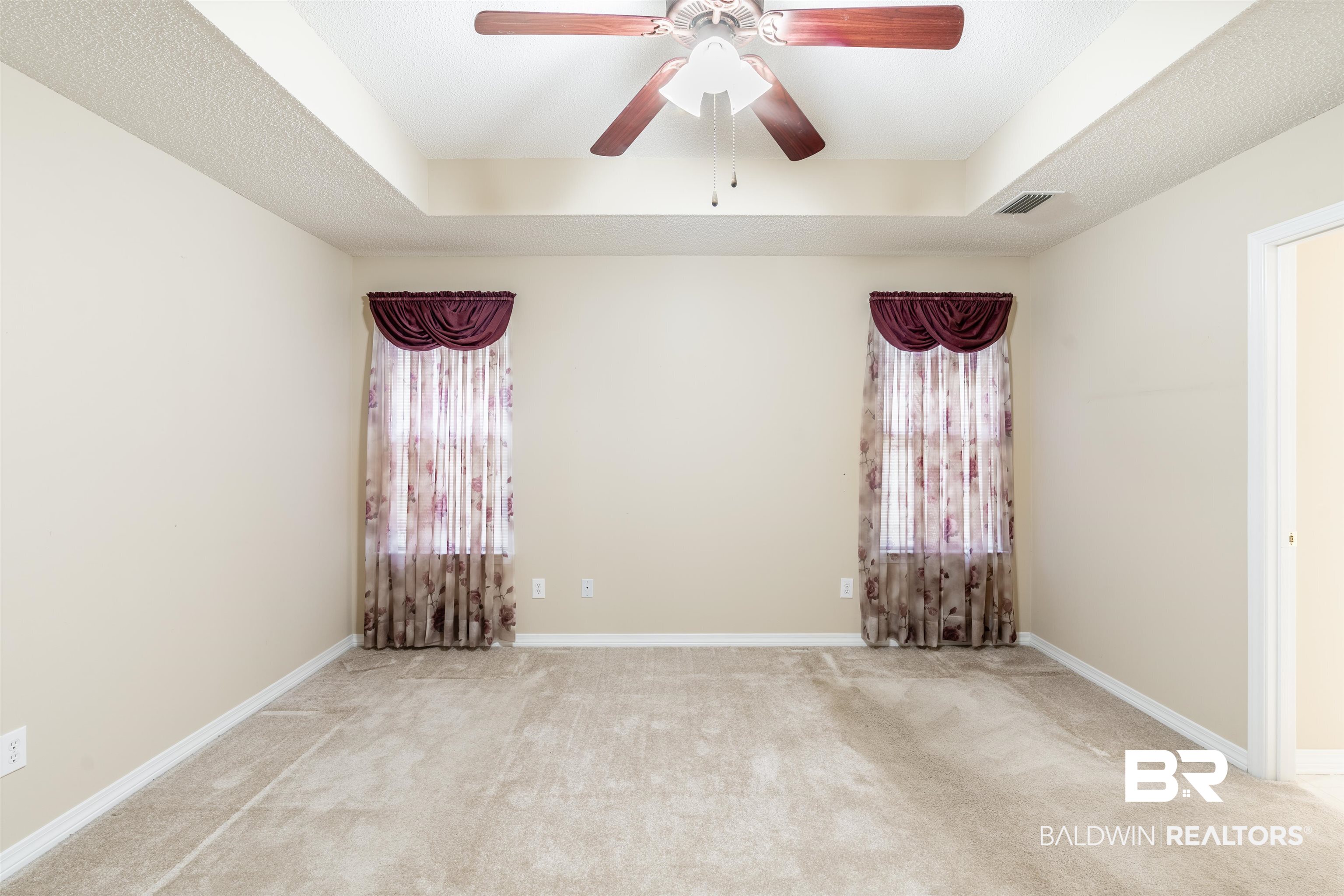 1784 Harrington Way Mobile, AL 36695 - Photo 10 of 18 Unfurnished room featuring ceiling fan, a tray ceiling, and light carpet