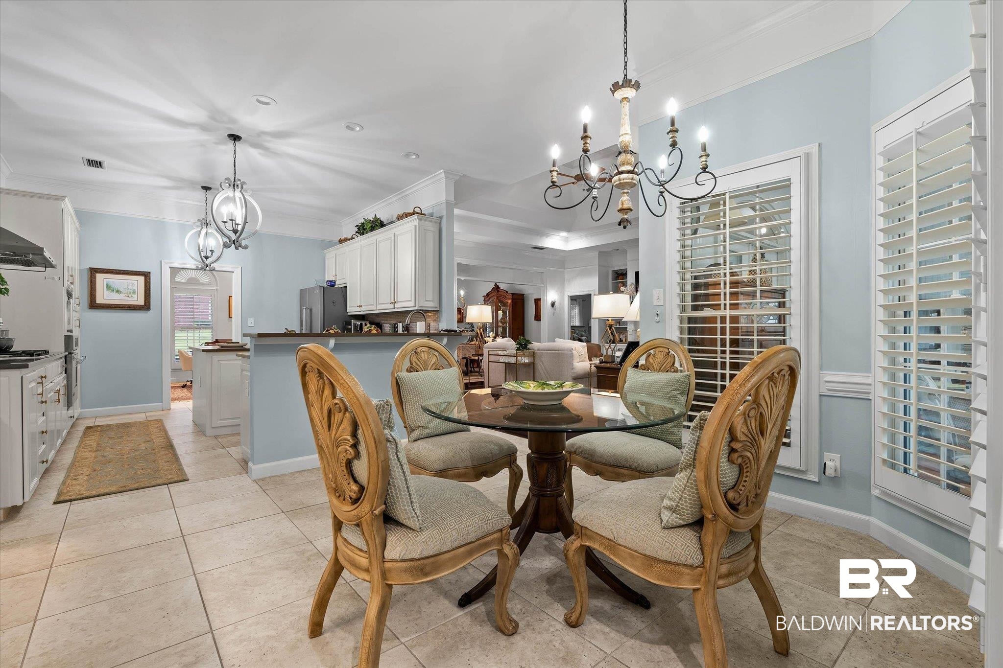 136 Old Mill Road Fairhope, AL 36532 - Photo 9 of 36 Kitchen and dining area featuring light-toned tile flooring, light blue wall paint, white cabinetry, and a glass-top round table