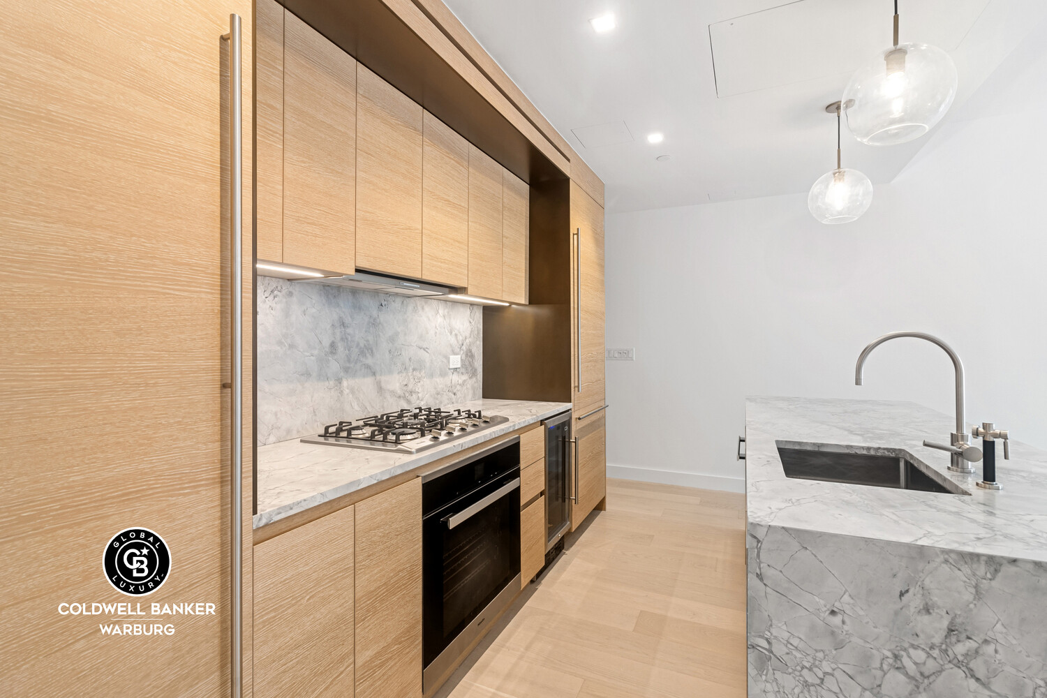 215 West 28th Street, Unit 7B Manhattan, NY 10001 - Photo 3 of 7 a kitchen with stainless steel appliances granite countertop a sink and a stove with wooden floor