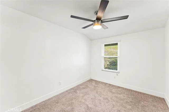 an empty room with a window and a fan