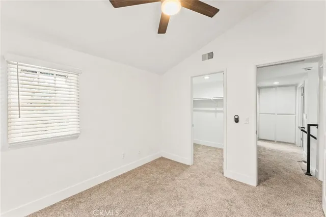 an empty room with a window and a ceiling fan
