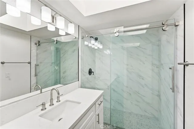 a bathroom with a sink mirror and a shower