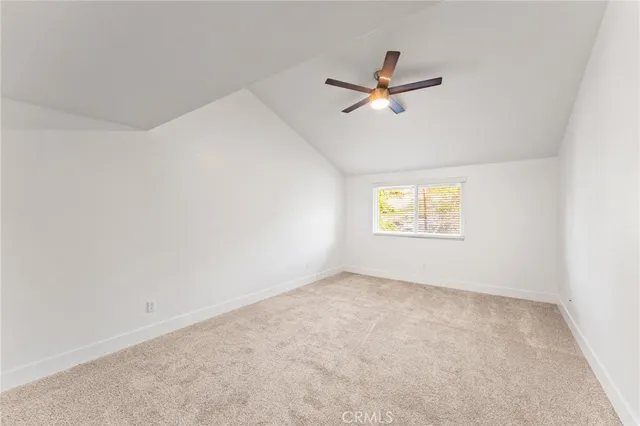 an empty room with a window and a ceiling fan