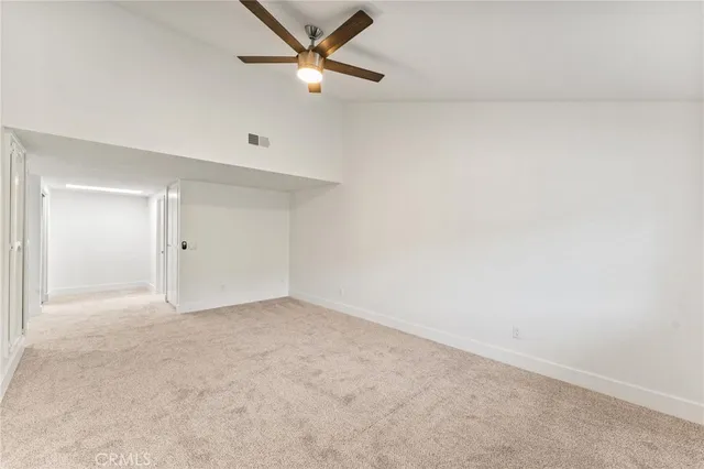 an empty room with closet and fan