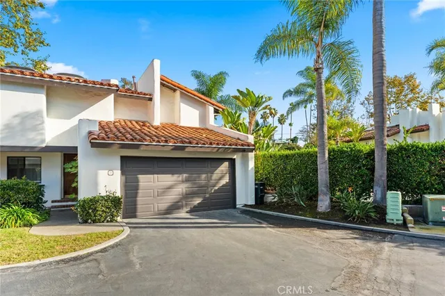 a view of a house with a yard and palm trees