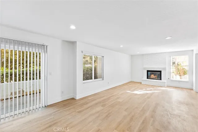 a view of an empty room with a window and fireplace