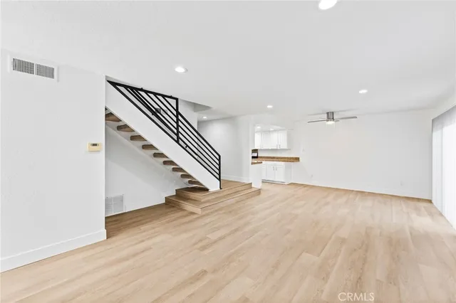 a view of a hallway with wooden floor and staircase