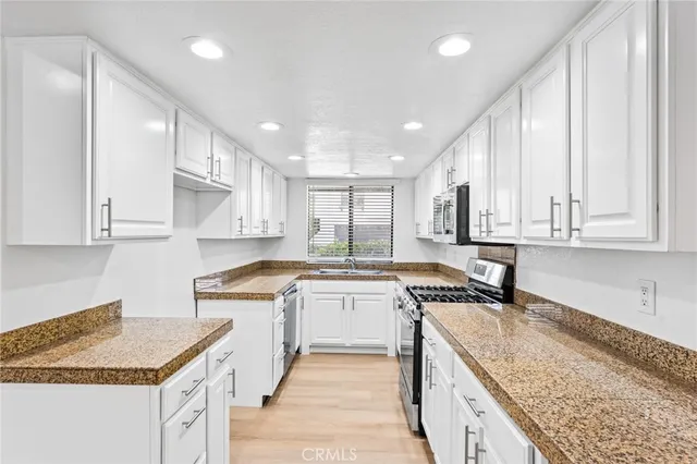 a kitchen with a stove sink and cabinets