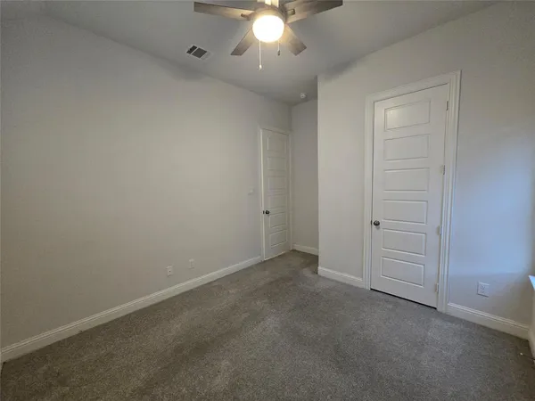 an empty room with a window and a fan