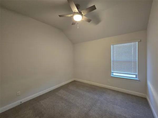 an empty room with closet and a ceiling fan