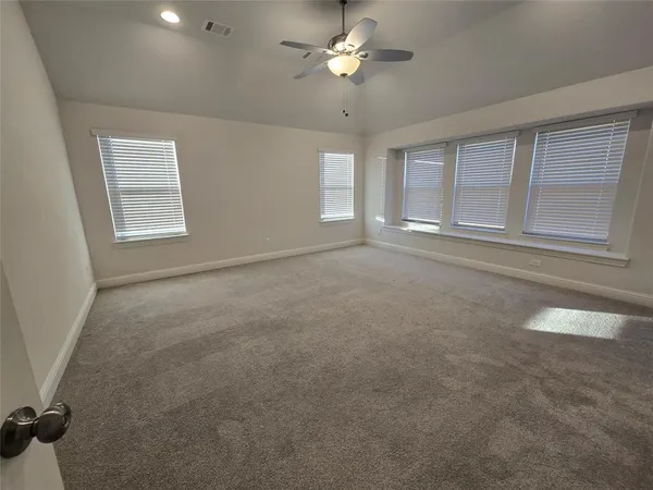 a view of an empty room with a chandelier fan