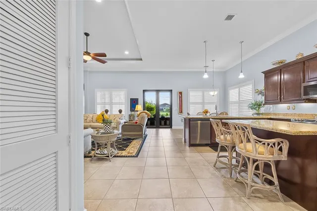 a kitchen with kitchen island granite countertop wooden cabinets a refrigerator and a sink