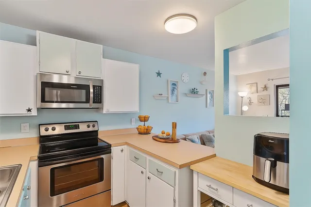 a kitchen with stainless steel appliances a stove a sink a microwave and cabinets