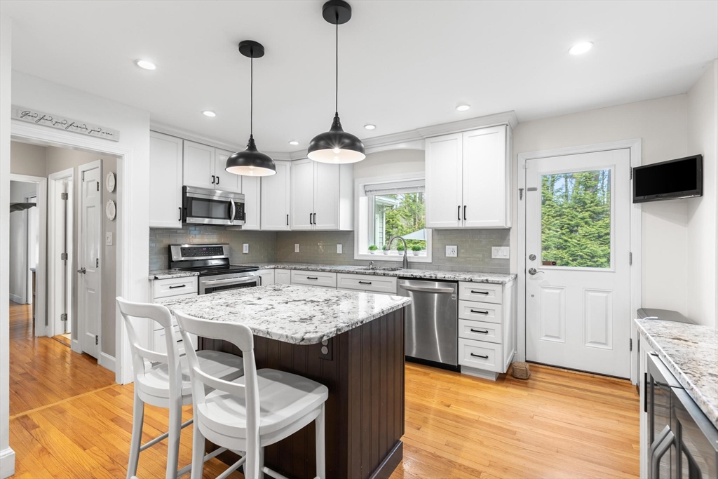 89 Haggetts Pond Road Andover, MA 01810 - Photo 6 of 42 a kitchen with stainless steel appliances granite countertop a stove a sink a refrigerator a stove a oven a kitchen island with a island and chairs