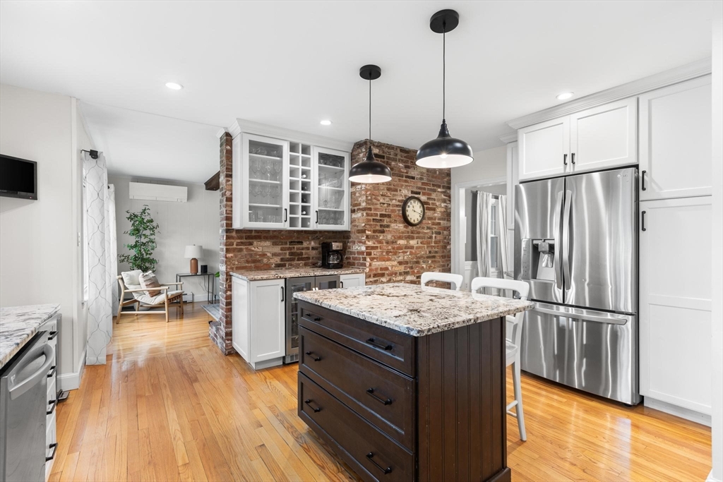 89 Haggetts Pond Road Andover, MA 01810 - Photo 8 of 42 a kitchen with kitchen island a counter top space a sink a refrigerator and wooden floor