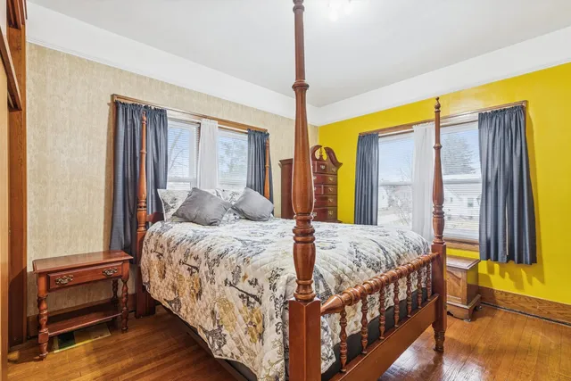 a bedroom with a bed and large window