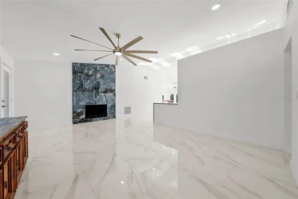 a kitchen with stainless steel appliances white cabinets a stove a sink a dining table and chairs