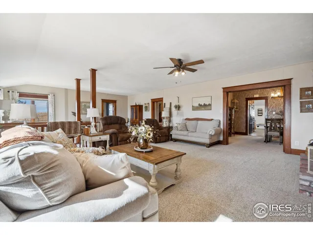 a living room with furniture a dining table and a large window