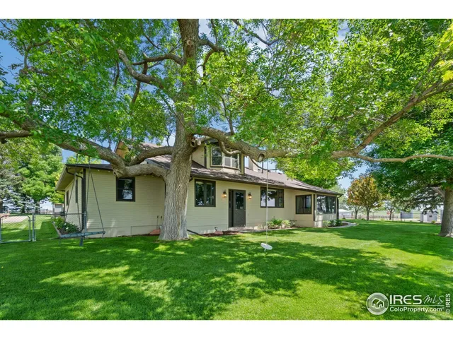 a kitchen with stainless steel appliances granite countertop a refrigerator a stove a dining table and chairs with wooden floor