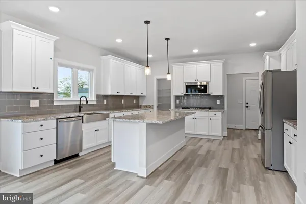a large kitchen with stainless steel appliances sink a microwave and cabinets