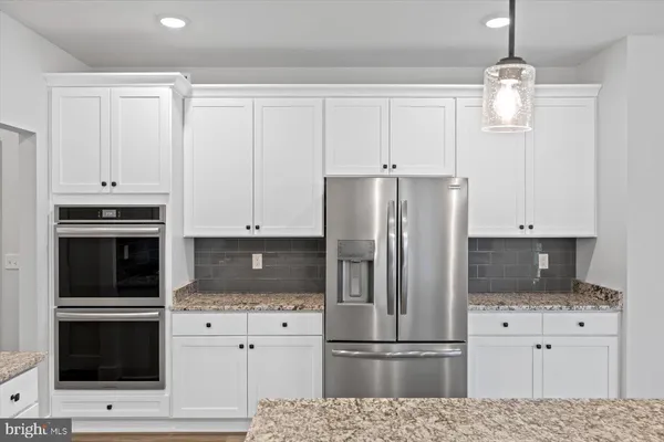 a kitchen with cabinets stainless steel appliances and wooden floor