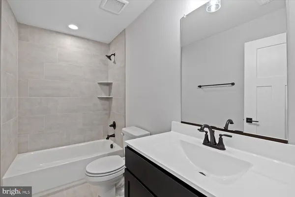 a bathroom with a sink a toilet and a large mirror