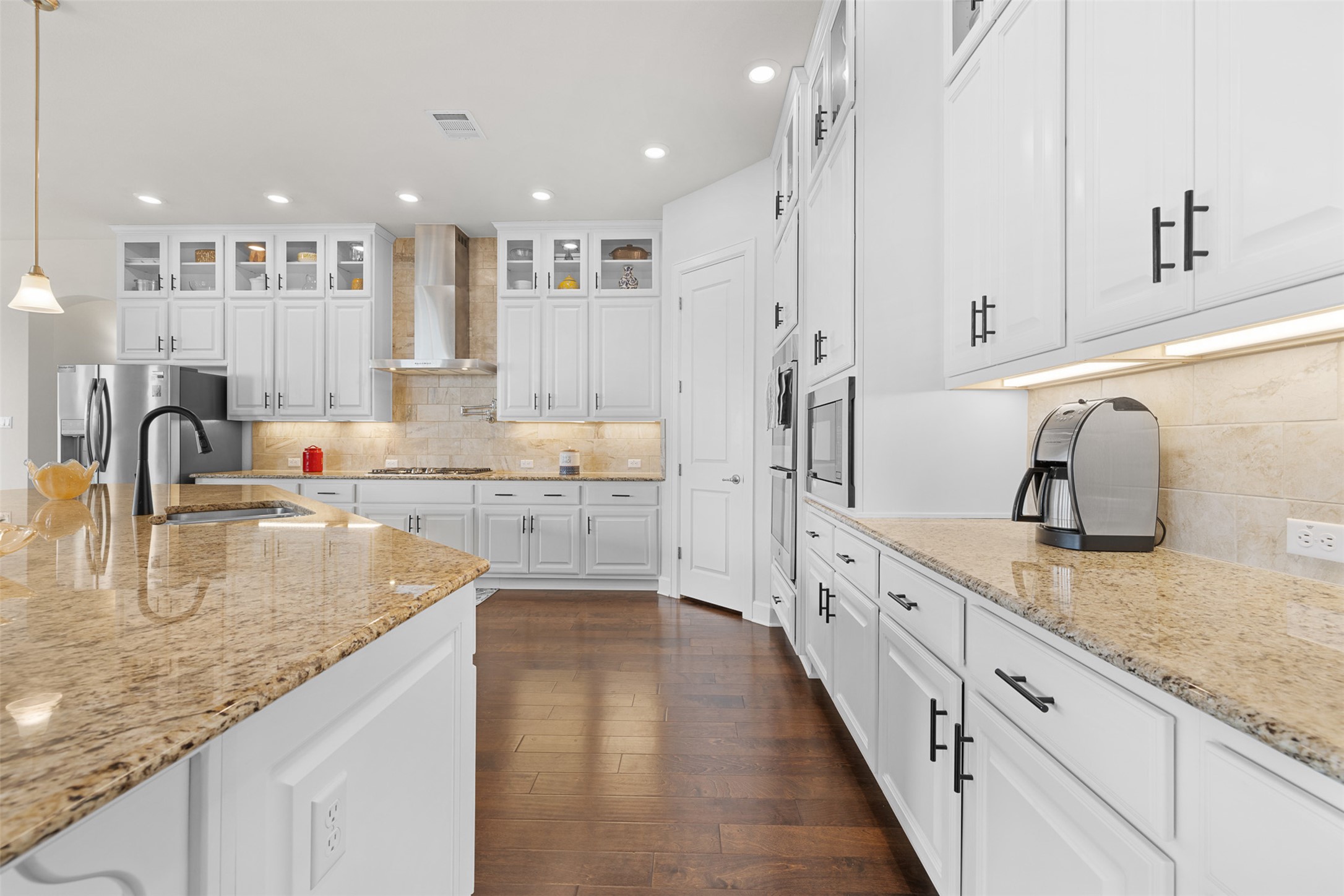 235 Chestnut Crossing Burnet, TX 78611 - Photo 17 of 39 a large kitchen with granite countertop a sink and white cabinets