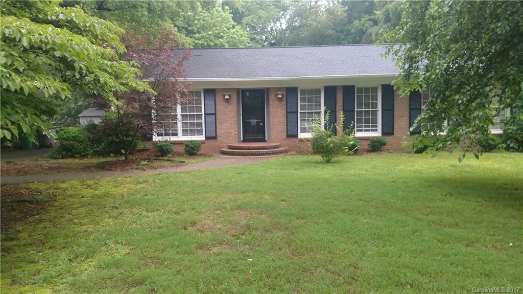 a front view of a house with yard and green space