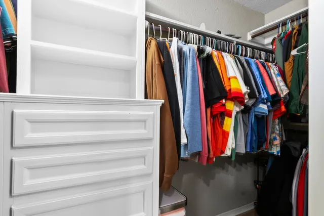 a view of walk in closet with clothes and shoes