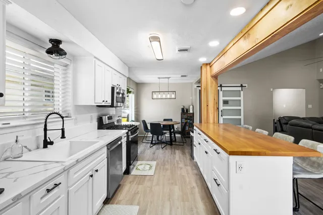 a large kitchen with kitchen island a large counter space a sink stainless steel appliances and cabinets
