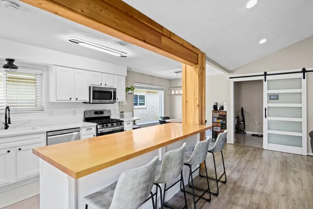 a large kitchen with kitchen island a large counter space and stainless steel appliances