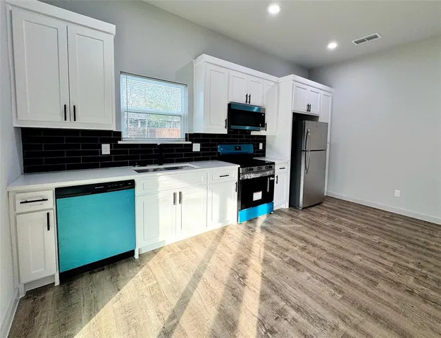 a kitchen with stainless steel appliances granite countertop a refrigerator and a stove top oven