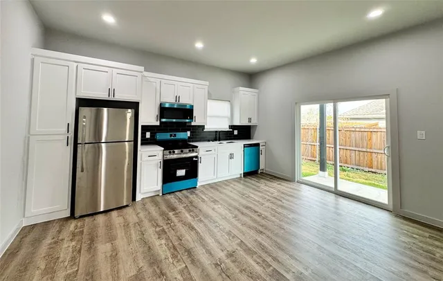 a kitchen with white cabinets and stainless steel appliances