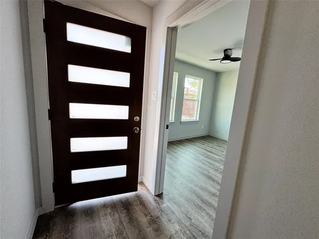 a view of an empty room with wooden floor