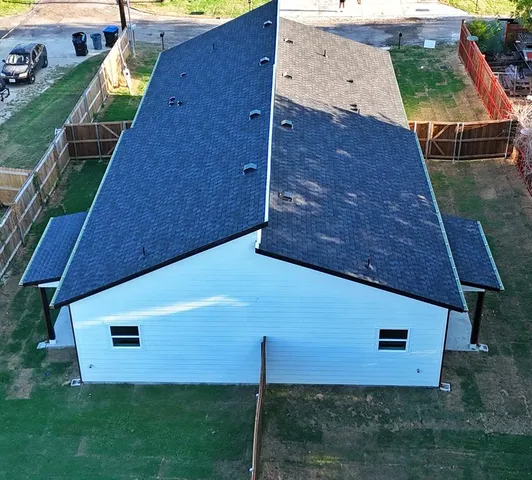 an aerial view of a house with a yard