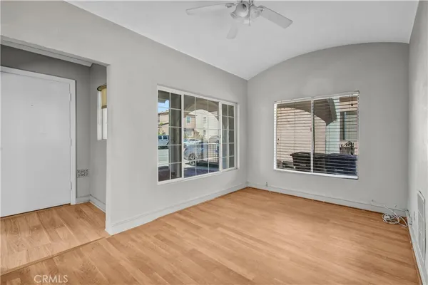 a view of an empty room with a window and wooden floor