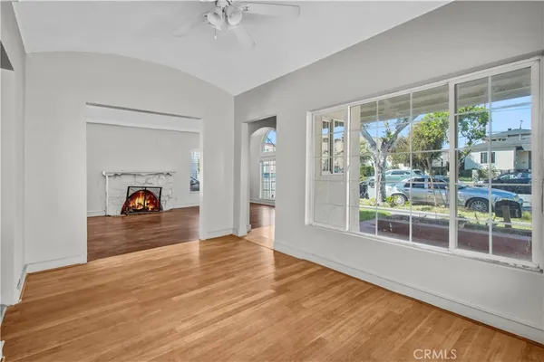 a view of empty room with wooden floor and fan