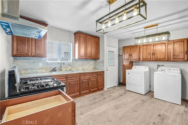 a kitchen with granite countertop a stove top oven sink and cabinets