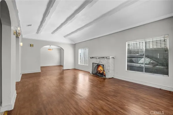 a view of a livingroom with wooden floor a fireplace and window