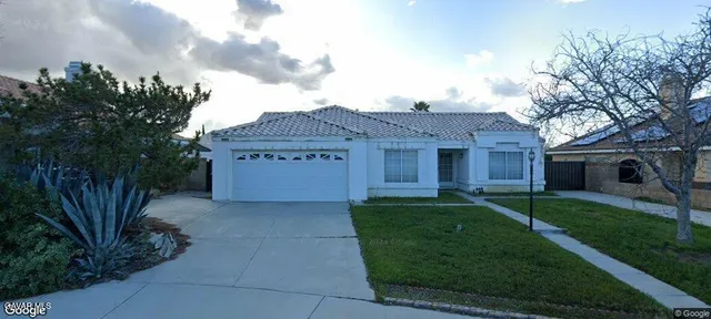 a front view of a house with a garden and yard