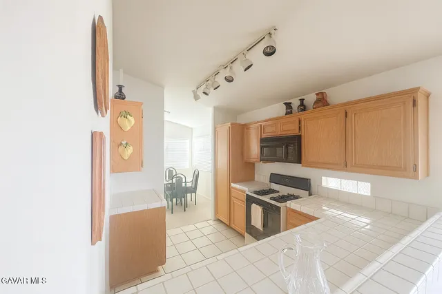 a kitchen with stainless steel appliances kitchen island granite countertop a refrigerator and a stove top oven